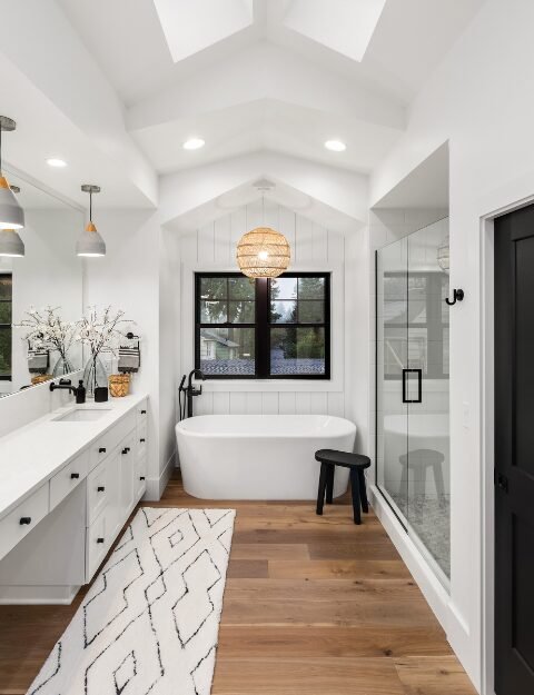 Elegant Bathroom Remodel in Matthews, NC, showcasing a farmhouse style master bathroom with large mirror, shower, bathtub, and double vanity.